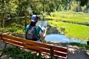 Randonnée à l'Etang de Devin au Bonhomme en Alsace : petite pause avec une carte de randonnée sur un banc